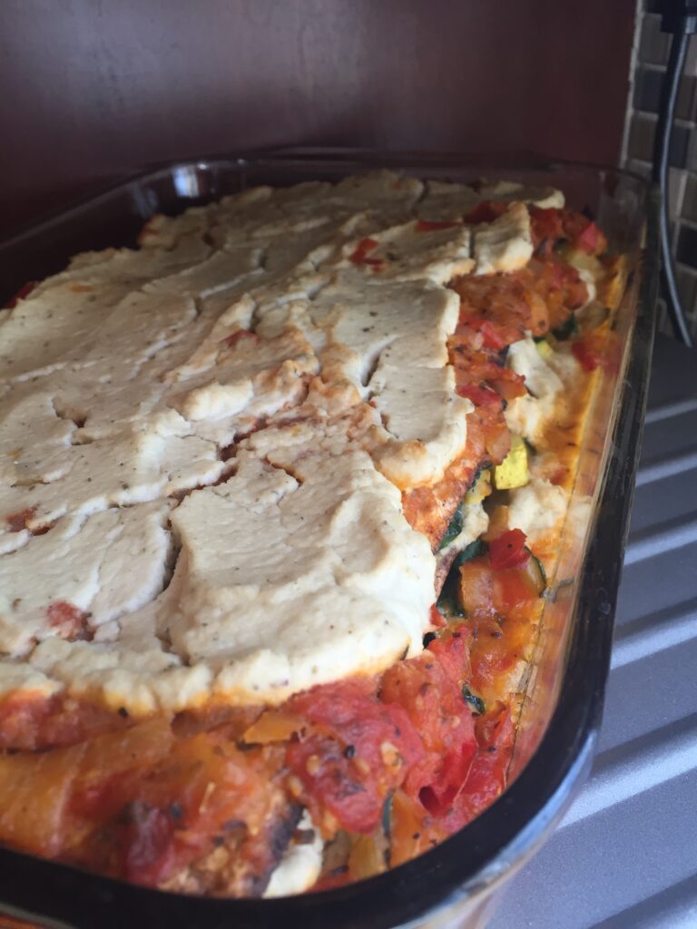 vegan matzah lasagna with cauliflower cashew ricotta in a glass baking dish